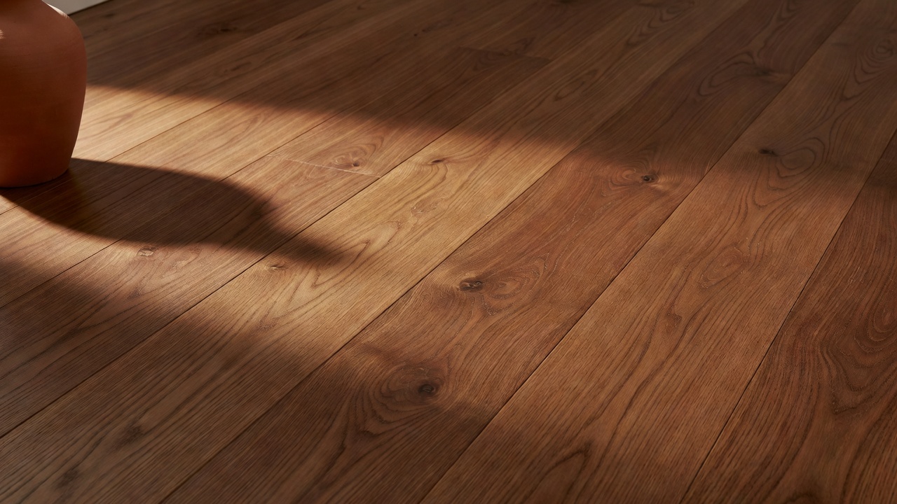close-up photorealistic detail of satin-finish chestnut hardwood floorboards catching warm side light, subtle low sheen highlighting natural grain and warm unde